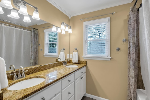 full bath featuring double vanity, ornamental molding, a sink, and baseboards