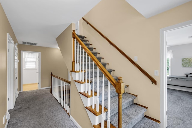 staircase with carpet flooring, visible vents, and baseboards