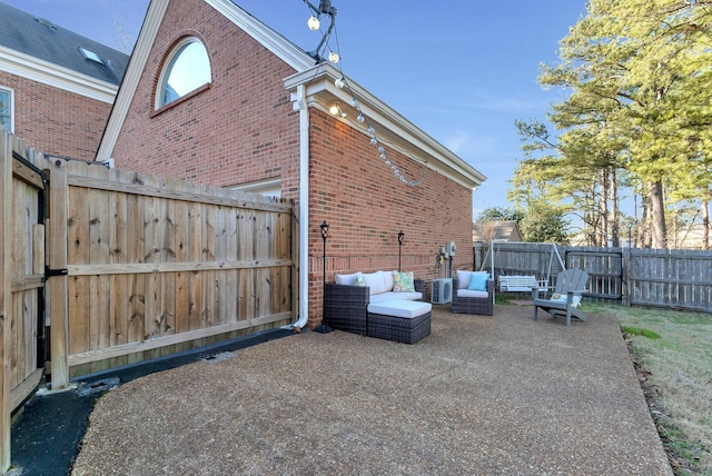 view of property exterior featuring fence, an outdoor hangout area, a patio, and brick siding