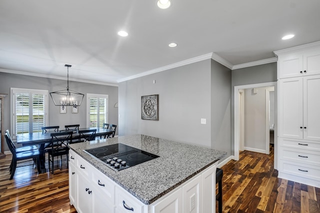 kitchen featuring light stone counters, black electric cooktop, a kitchen island, white cabinetry, and dark wood-style floors