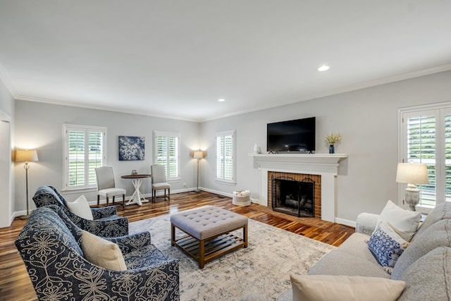 living room with ornamental molding, a fireplace, baseboards, and wood finished floors