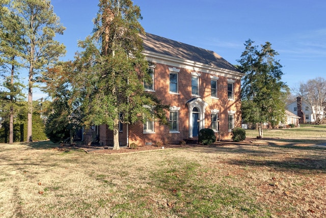 colonial inspired home featuring a front lawn and brick siding