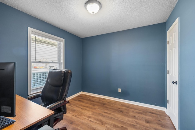 office with a textured ceiling, baseboards, and wood finished floors