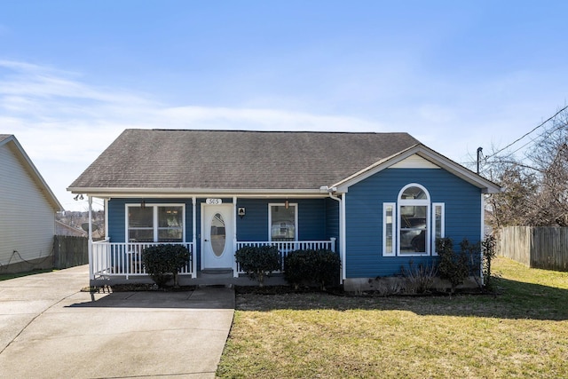 view of front of property with a shingled roof, fence, a front lawn, and a porch