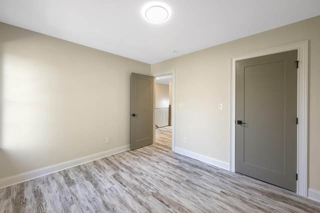 unfurnished bedroom featuring light wood finished floors and baseboards