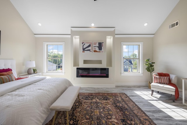 bedroom with multiple windows, visible vents, and vaulted ceiling