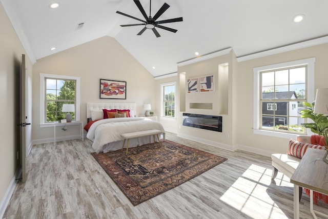 bedroom with visible vents, baseboards, a glass covered fireplace, lofted ceiling, and light wood-style flooring