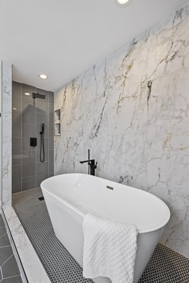 full bath featuring tiled shower, a freestanding bath, tile walls, and tile patterned floors