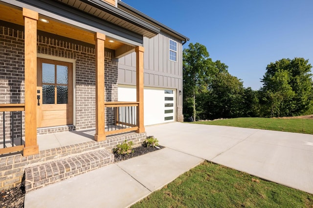 exterior space with board and batten siding, brick siding, driveway, and an attached garage