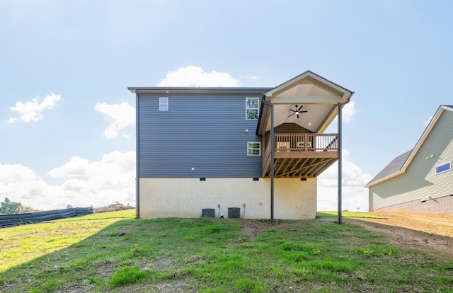 back of property with a wooden deck, a yard, cooling unit, and a ceiling fan