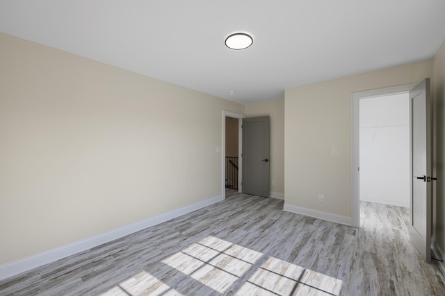 empty room featuring light wood-type flooring and baseboards