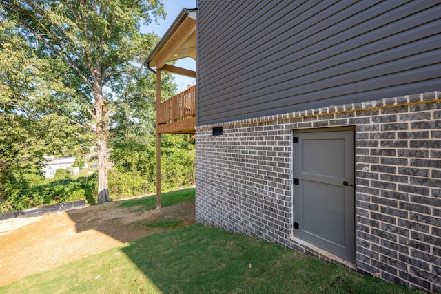 exterior space with brick siding and a lawn