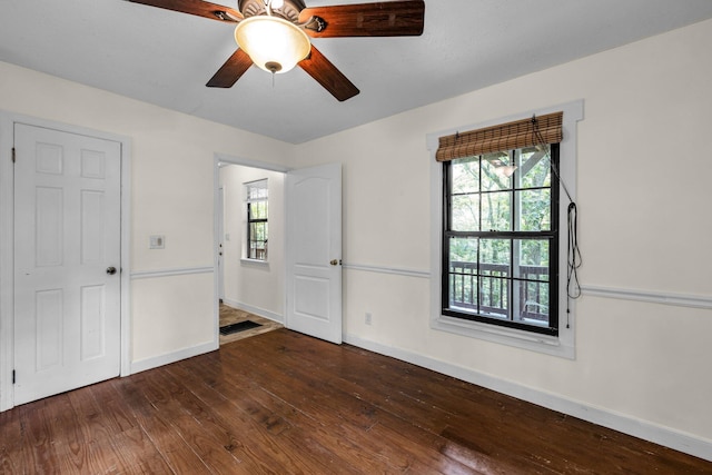 unfurnished bedroom featuring dark wood-style flooring, ceiling fan, and baseboards