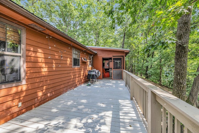 deck with a sunroom and a grill