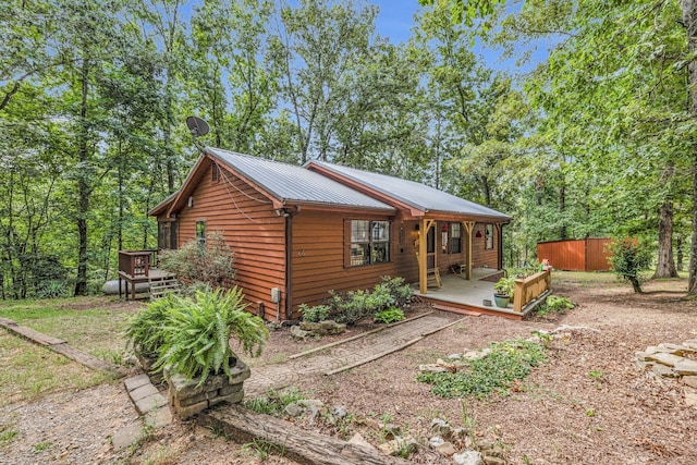 view of front of home featuring metal roof and a wooden deck