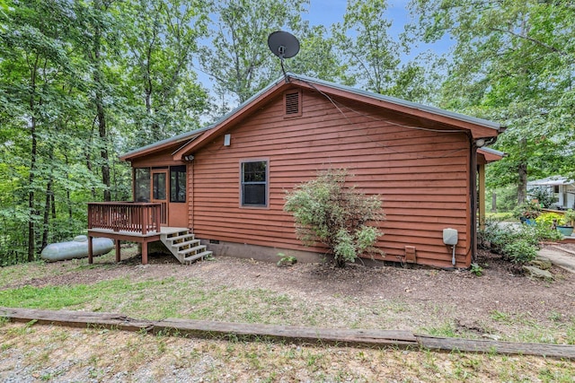 view of property exterior featuring crawl space and a wooden deck