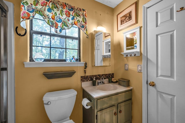 bathroom with toilet, backsplash, and vanity