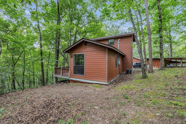 view of side of property featuring central air condition unit and a deck