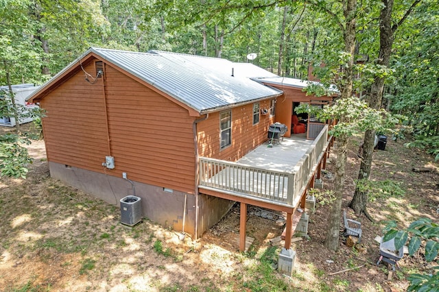 view of property exterior with crawl space, metal roof, cooling unit, and a wooden deck