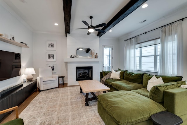 living room featuring beamed ceiling, a fireplace, visible vents, and crown molding