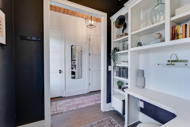 mudroom featuring dark wood-type flooring, baseboards, and an inviting chandelier