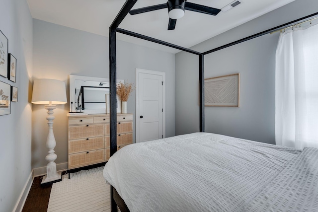 bedroom featuring baseboards, visible vents, ceiling fan, and dark wood finished floors