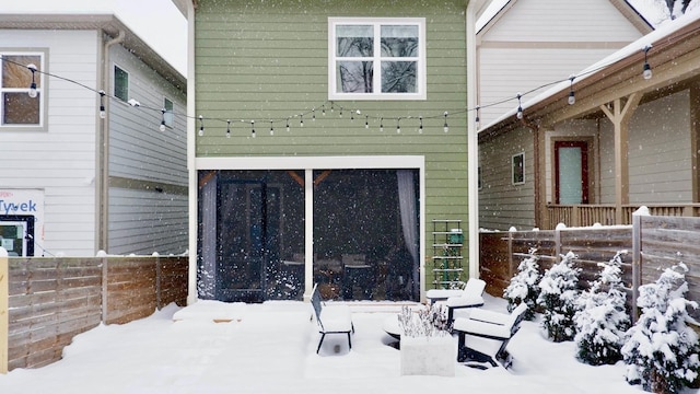 snow covered property with fence