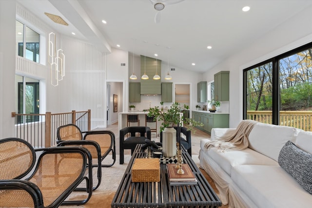 living area featuring high vaulted ceiling, recessed lighting, and a healthy amount of sunlight