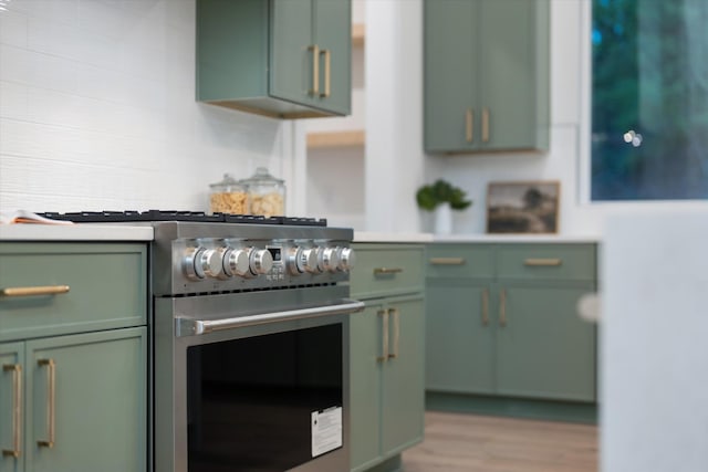 kitchen featuring green cabinets, high end range, and light countertops