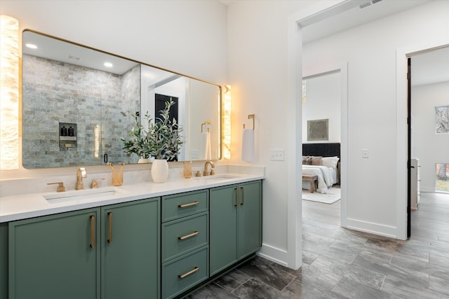 ensuite bathroom featuring double vanity, connected bathroom, a sink, and recessed lighting