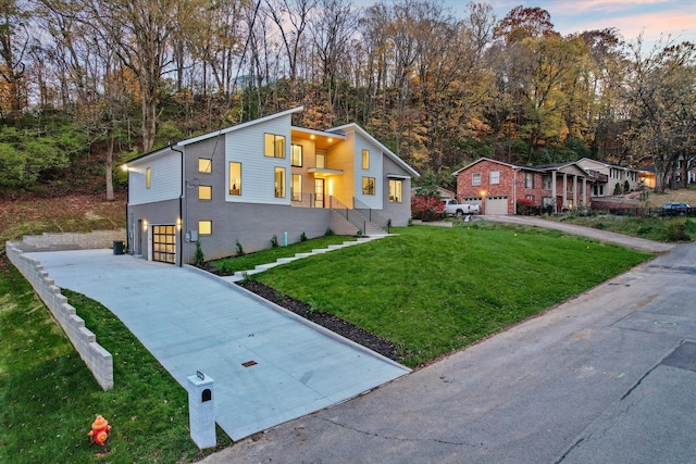 view of front facade featuring driveway, brick siding, an attached garage, and a front yard