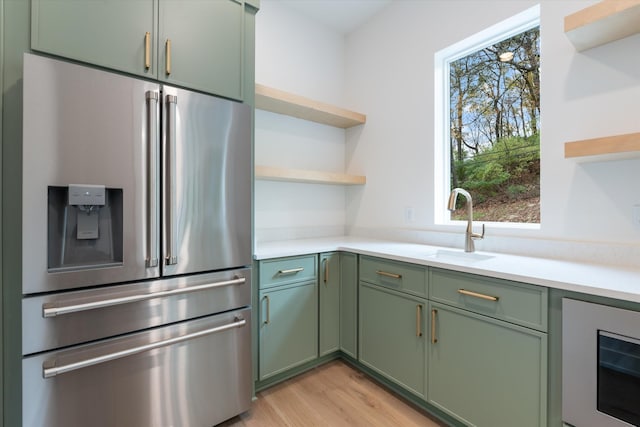 kitchen featuring green cabinets, light countertops, high end refrigerator, and open shelves