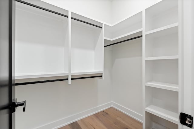 walk in closet with wood finished floors