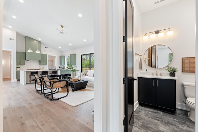 full bathroom with visible vents, toilet, ceiling fan, vanity, and wood finished floors