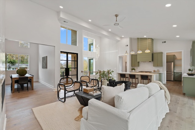 living room featuring light wood-type flooring, a healthy amount of sunlight, and recessed lighting