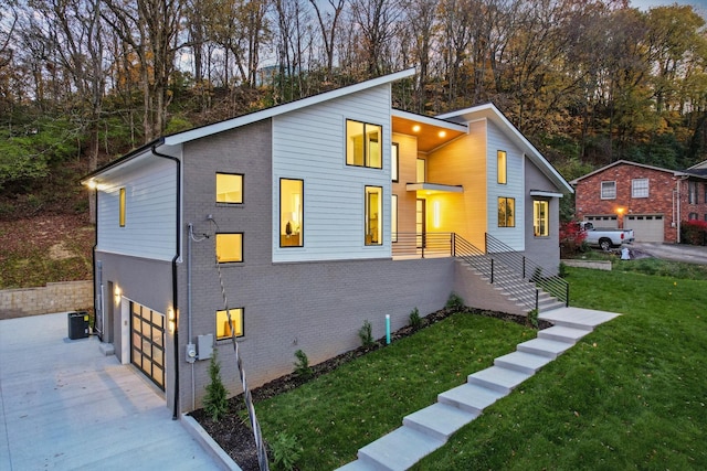 view of property exterior with central AC unit, brick siding, a lawn, and an attached garage