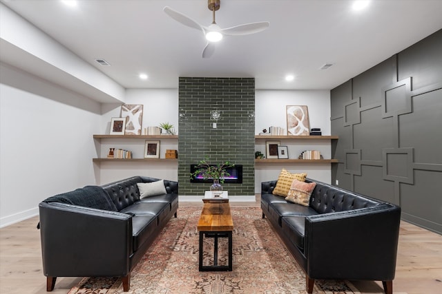 living room featuring a fireplace, recessed lighting, a ceiling fan, wood finished floors, and baseboards