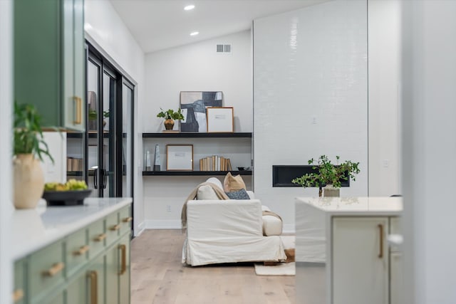 living area featuring lofted ceiling, visible vents, light wood-style flooring, and recessed lighting