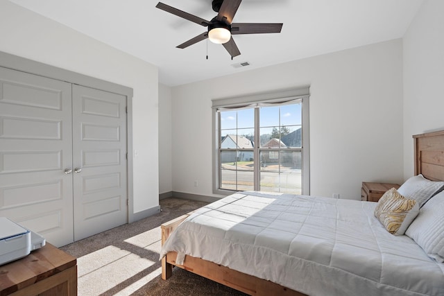 bedroom with a ceiling fan, visible vents, baseboards, a closet, and carpet