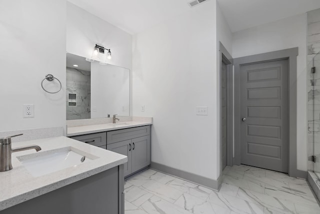 full bath with a sink, marble finish floor, two vanities, and a marble finish shower