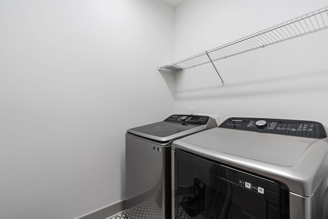 laundry area featuring laundry area, baseboards, and washer and clothes dryer