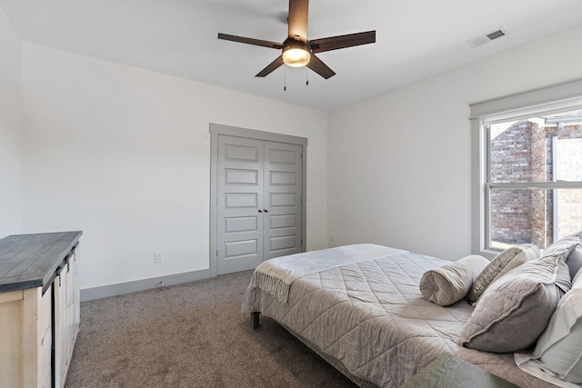 carpeted bedroom featuring ceiling fan, a closet, visible vents, and baseboards