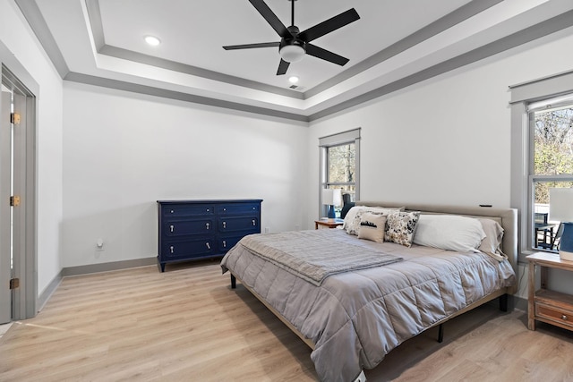 bedroom featuring light wood finished floors, recessed lighting, a raised ceiling, visible vents, and baseboards