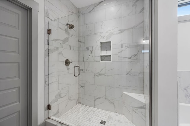 bathroom with a marble finish shower