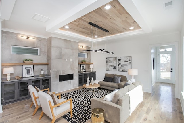 living area featuring light wood finished floors, wooden ceiling, a raised ceiling, and recessed lighting