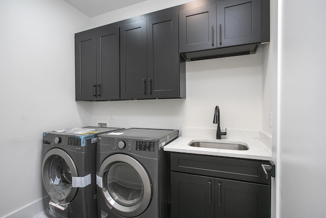 clothes washing area featuring cabinet space, separate washer and dryer, and a sink