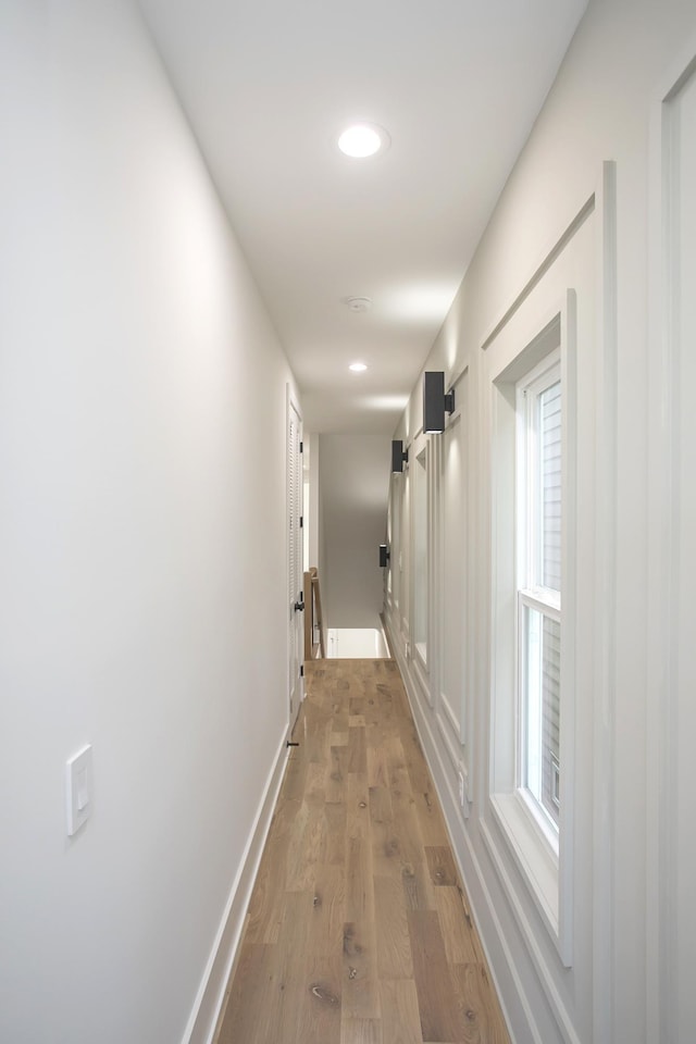 hall with baseboards, wood finished floors, and recessed lighting