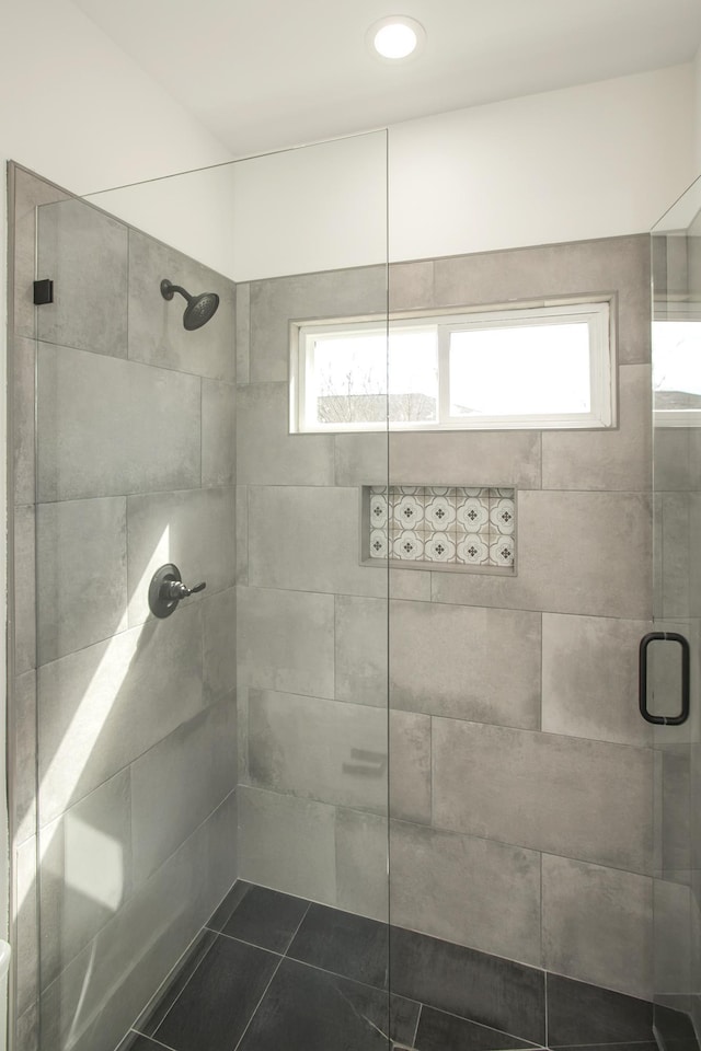 full bathroom with tile patterned flooring and tiled shower