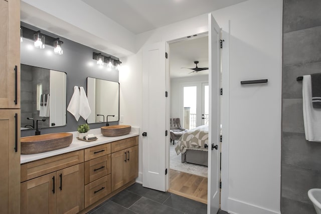 ensuite bathroom featuring ceiling fan, a sink, ensuite bath, and double vanity