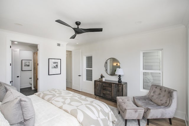 bedroom with visible vents, baseboards, a ceiling fan, wood finished floors, and crown molding